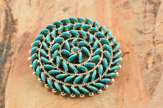 Stunning Pendant/Brooch featuring Genuine Sleeping Beauty Turquoise set in Sterling Silver. Beautiful Petit Point Design. Many days of painstaking work went into creating this Southwestern Art Masterpiece.  Created by Master Zuni Artists Octavious and Irma Seowtewa.  Signed by the artists. Free 18" Sterling Silver Chain with purchase of pendant. The Zuni Pueblo is located in New Mexico, Land of Enchantment.